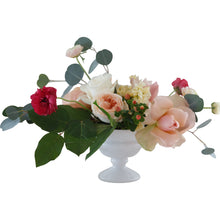 A peach and blush garden-style arrangement in a white footed bowl, suitable for a wedding centerpiece
