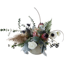 An earthy, organic, textural flower arrangement in a concrete vessel