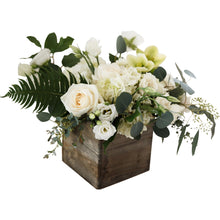 A lush, white and green centerpiece in a wooden box